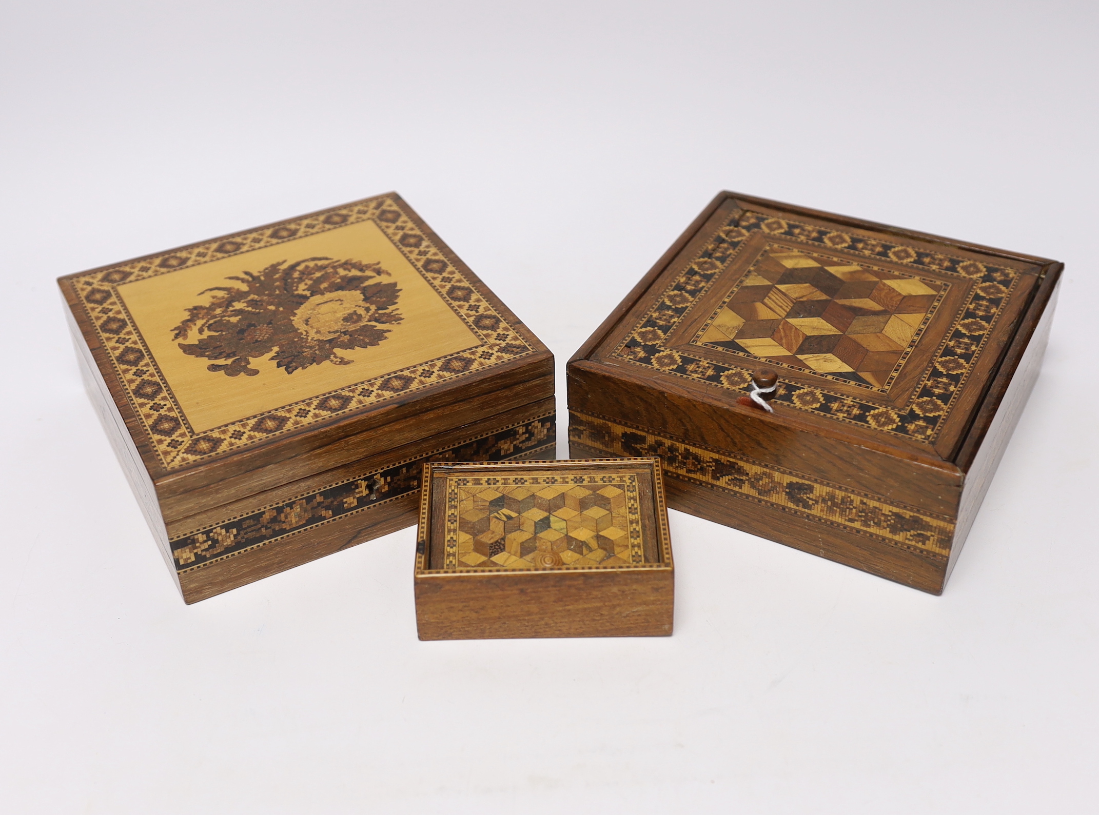 Three Tunbridgeware boxes, two decorated with perspective cube marquetry, the third with floral tesserae mosaic, largest 15.5cm